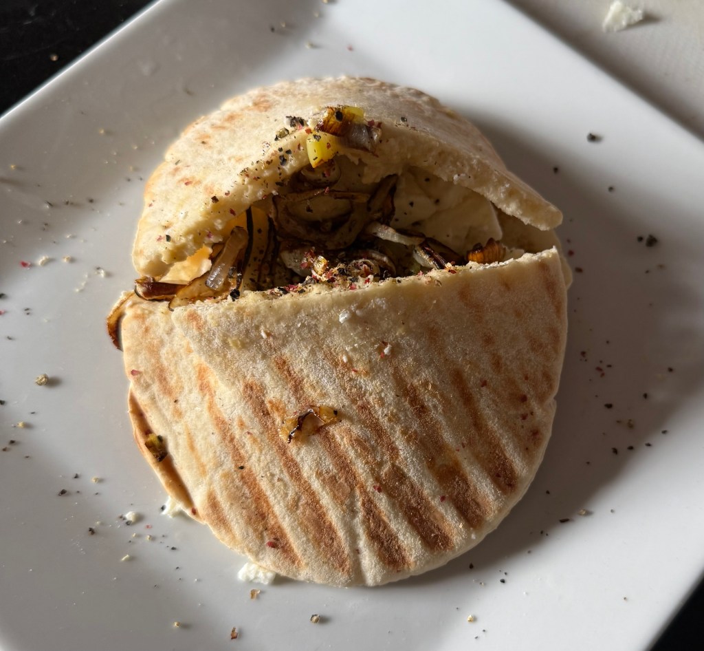 Pitta sandwich with hummus, feta, and caramelized&nbsp;onions